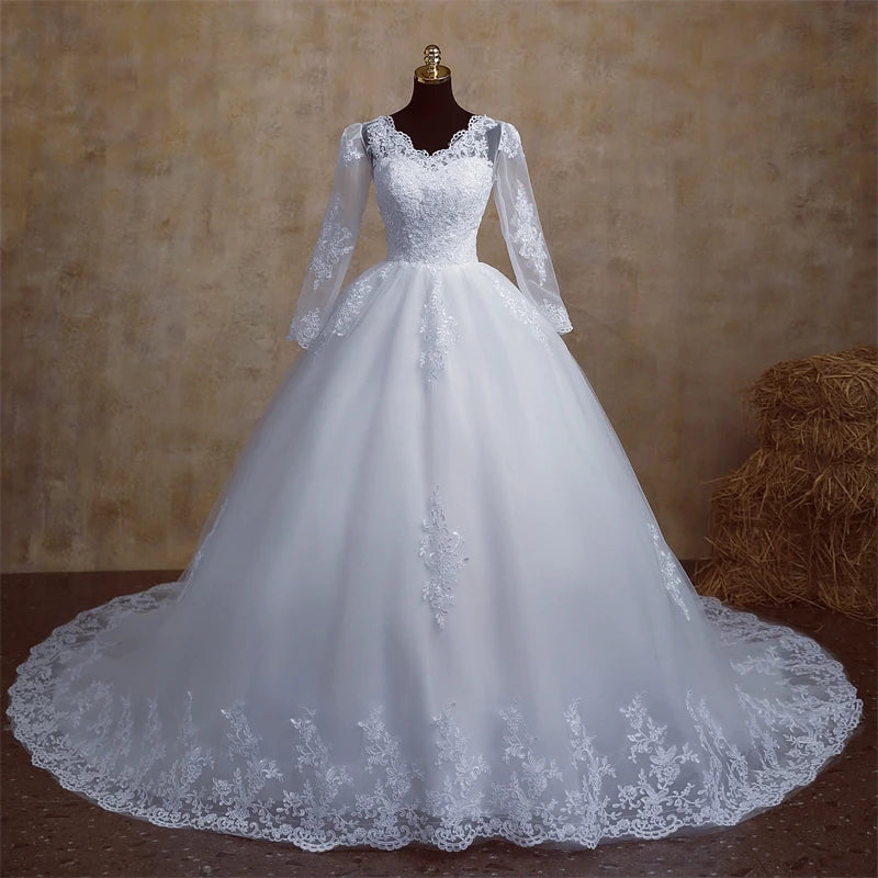 A mannequin displaying a white, V-neck plus size wedding dress with delicate lace details on the long sleeves and bodice.