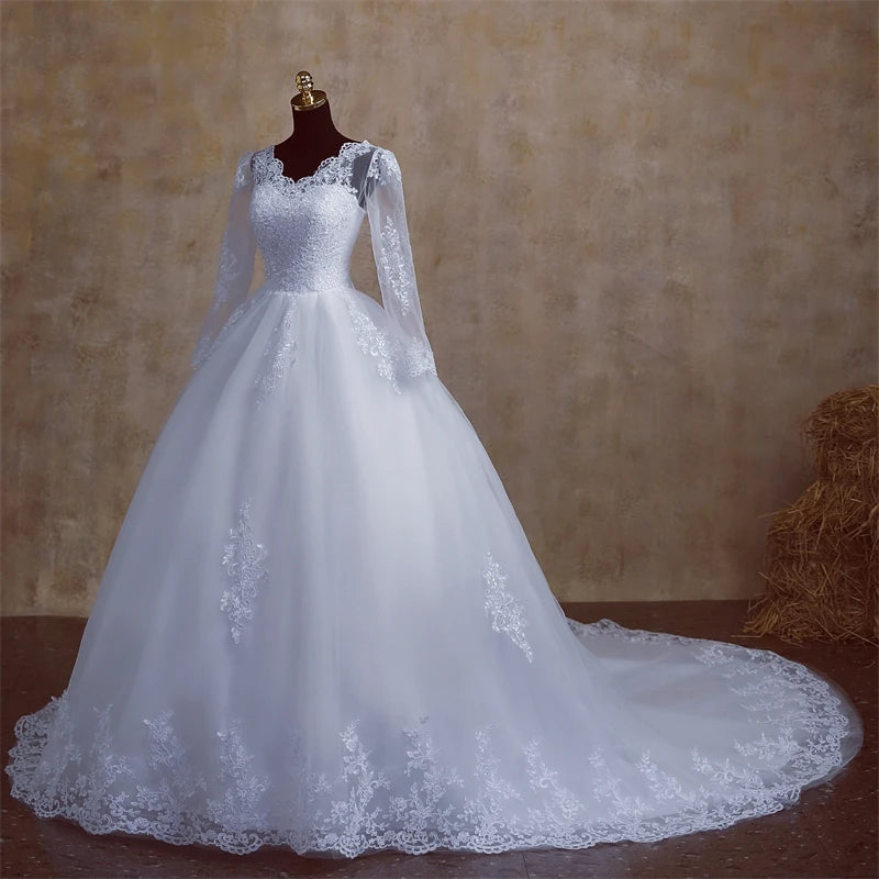 Front view of a white, long-sleeve V-neck wedding dress for plus size brides, highlighting the lace embroidery on the skirt.