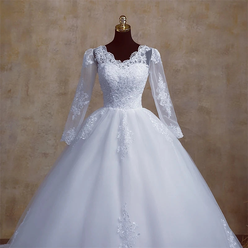 A mannequin dressed in a long-sleeve plus size bridal gown, emphasizing the refined V-neckline and lace accents.