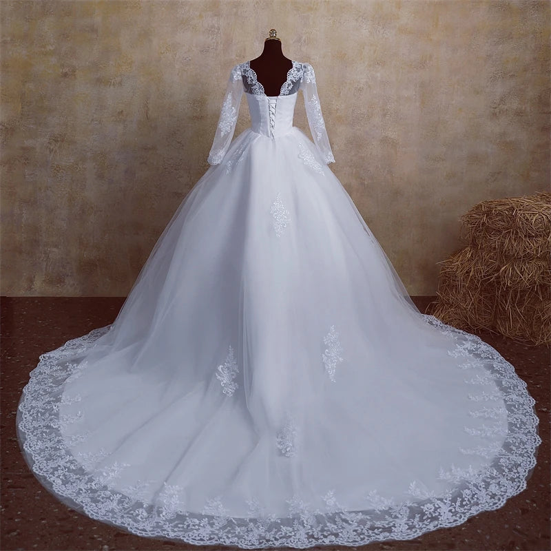 Back view of a V-neck, full-sleeve wedding dress on a mannequin, showcasing the lace-up corset back and an extensive train.