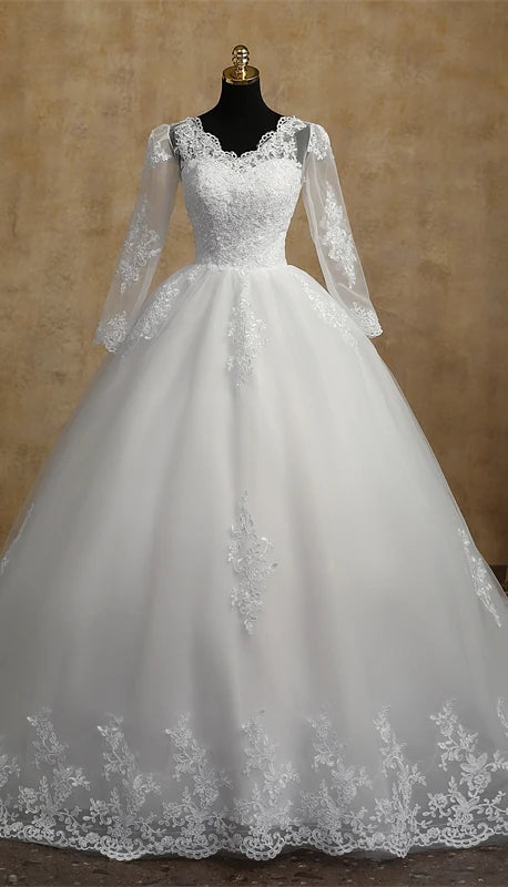 A front-view mannequin display of a white, full-sleeve V-neck wedding dress featuring delicate lace embroidery on the bodice and skirt.