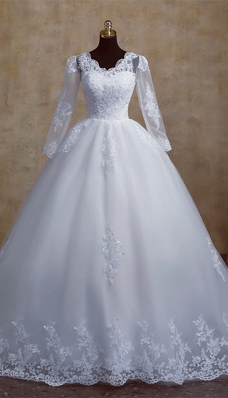 Mannequin display of a classic V-neck bridal gown with long lace sleeves, showcasing the balanced silhouette and detailed lace hem.