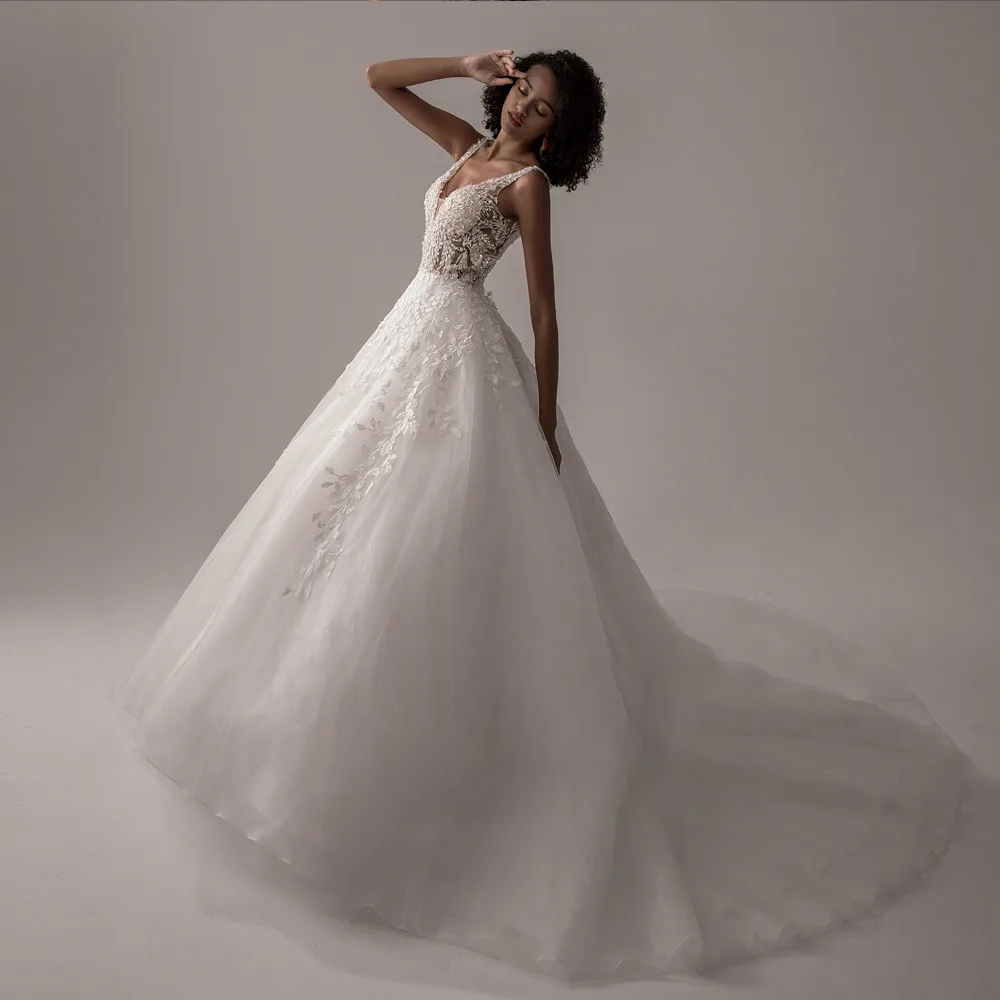Side profile of a romantic ivory A-line wedding dress with a deep V-neck and long, flowing train.