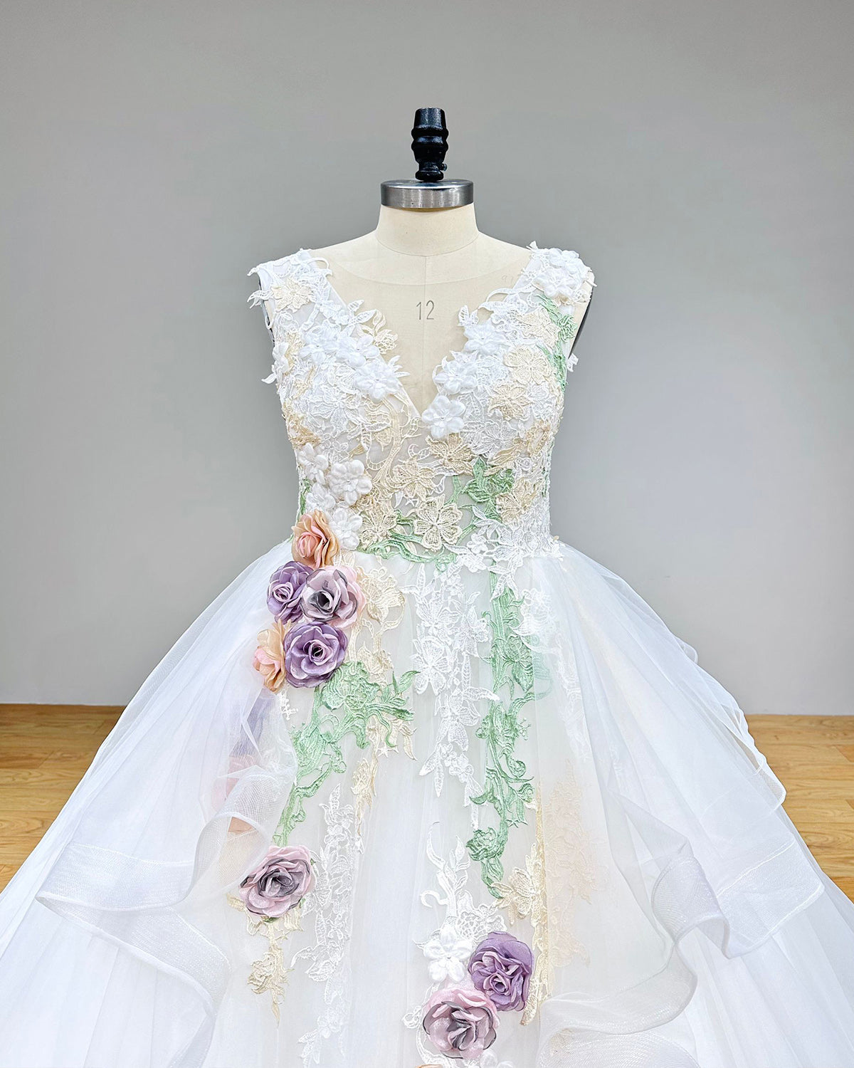 Close-up back bodice detail of a vintage wedding dress, highlighting the delicate sheer illusion back, fine button closure, and refined lace detailing on a mannequin.