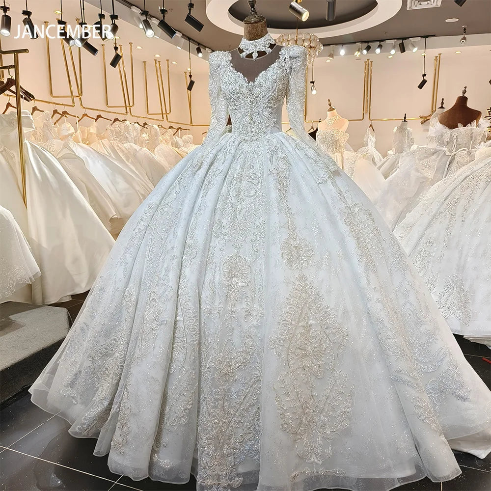 Full front display of a vintage princess ball gown wedding dress on a mannequin, highlighting the sheer lace long sleeves, high-neck choker collar, and symmetrical crystal appliques.