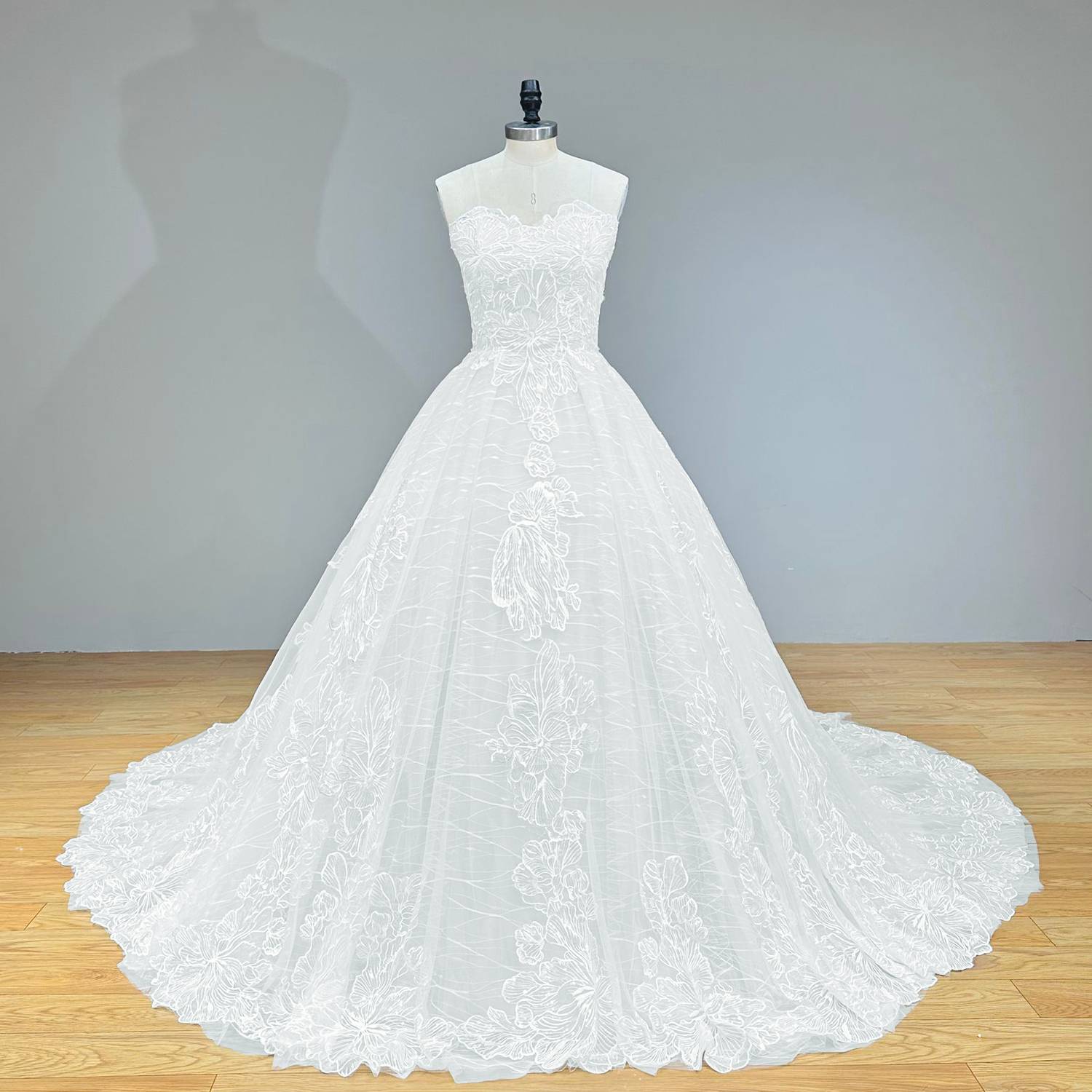Studio catalog shot of a classic princess-style sequined lace ball gown wedding dress with structured interior boning on a mannequin.