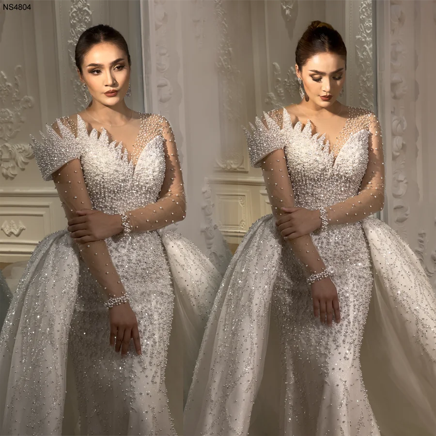 Close-up texture shot of the wedding dress skirt, featuring high-quality pearl accents, silver sequin embroidery, and layered sparkling tulle fabric.
