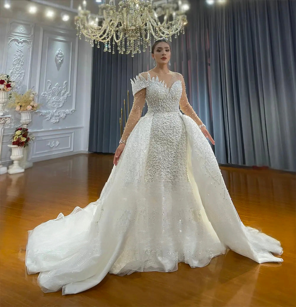 Side perspective of a sleeveless vintage ball gown wedding dress, highlighting the dramatic volume of the tiered sparkling skirt and pearl-encrusted waistline.