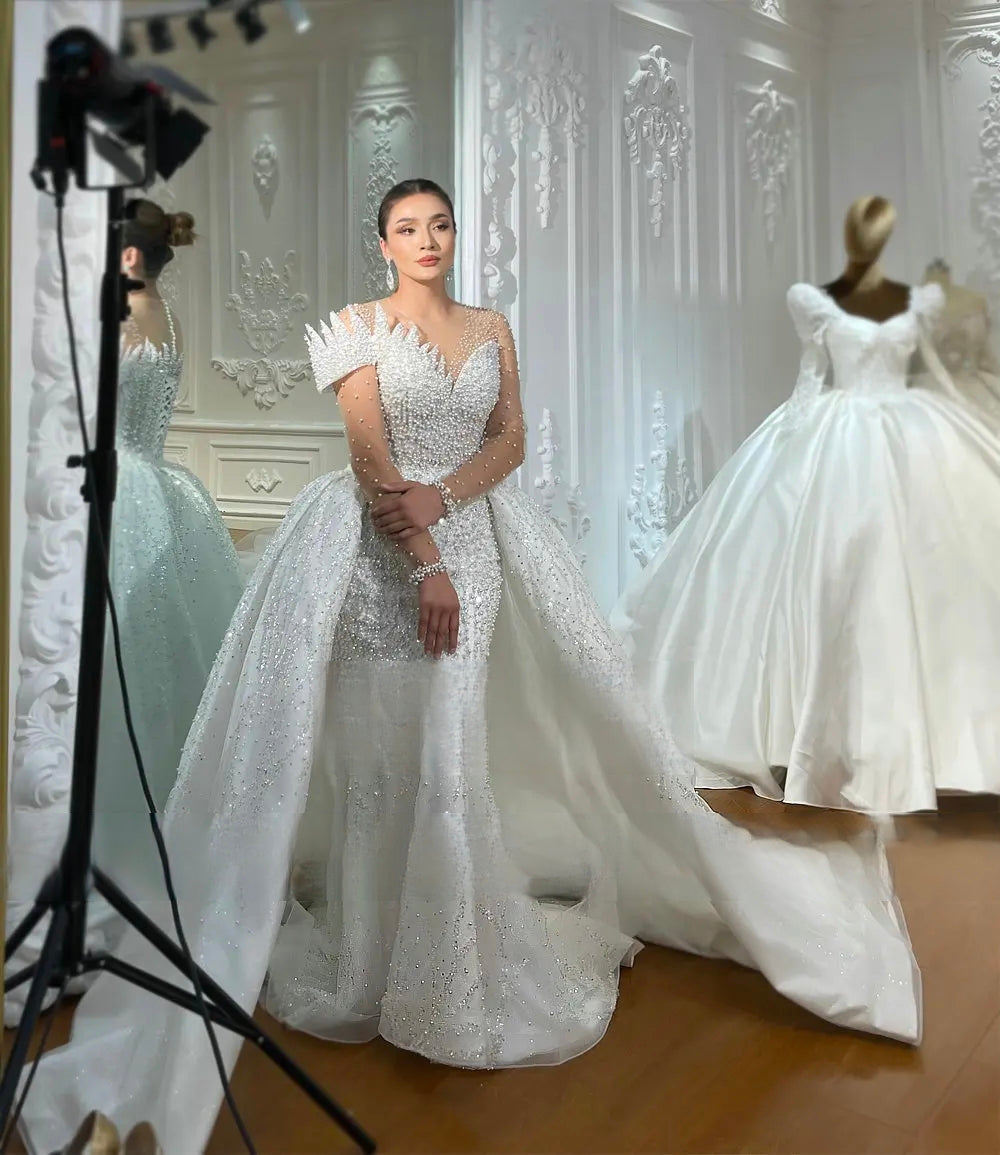 Detailed front view of the bridal bodice, showcasing a traditional lace-up corset back and delicate pearl-beaded straps.