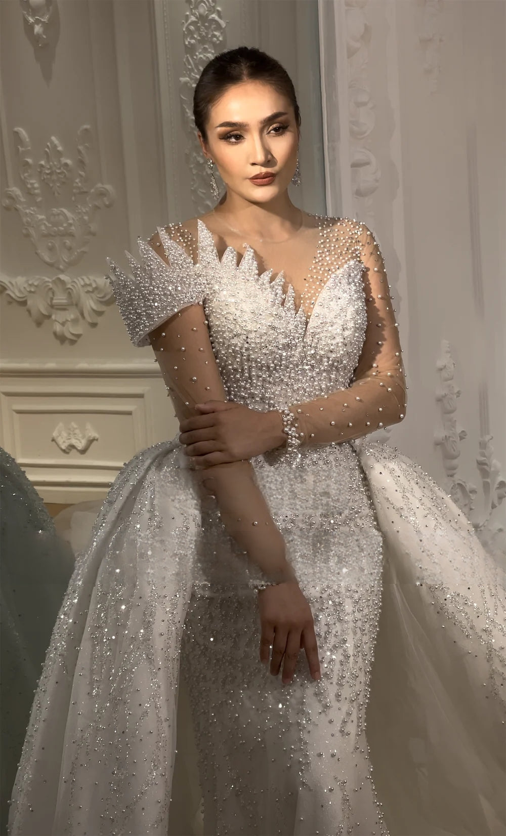 Close-up texture shot of the wedding dress skirt, featuring high-quality pearl accents, silver sequin embroidery, and layered sparkling tulle fabric.