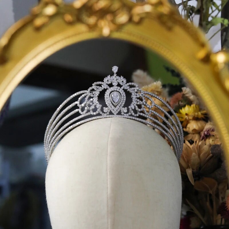 Close-up focus on the central teardrop frame and pave crystal arches of the wedding headband diadem crown resting on a canvas mannequin head.