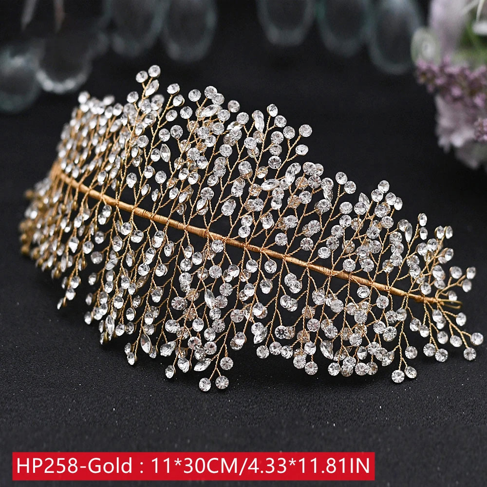 Perspective look at a wide gold wedding headwear tiara band meticulously crafted with tiny clear crystal sprigs over an adjustable wire base.