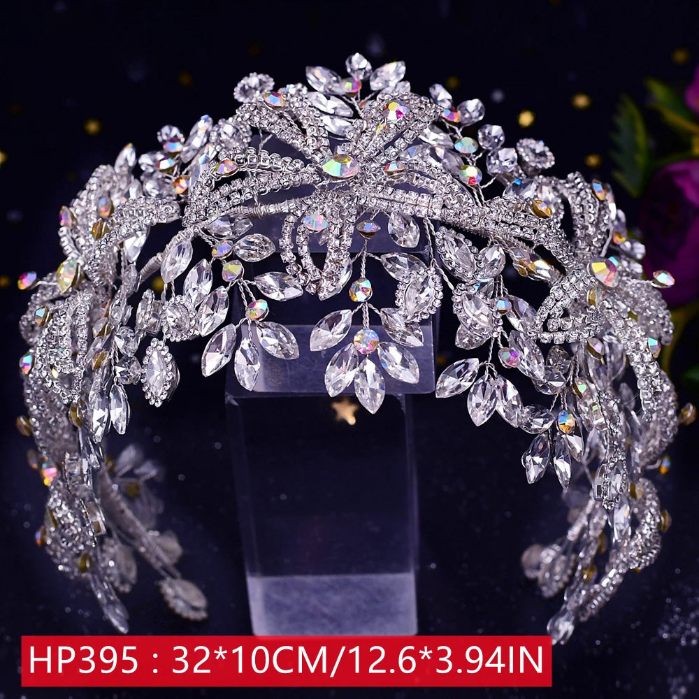 Front view of the HP395 silver rhinestone bridal crown tiara measuring 32 by 10 centimeters, heavily embellished with marquise stones on a clear stand.