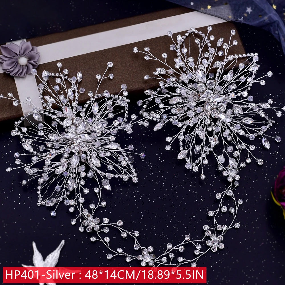 Wide flat lay view of the long HP401 silver rhinestone bridal hair vine, styled next to a brown gift presentation box and detailed with twin large crystal floral plaques.