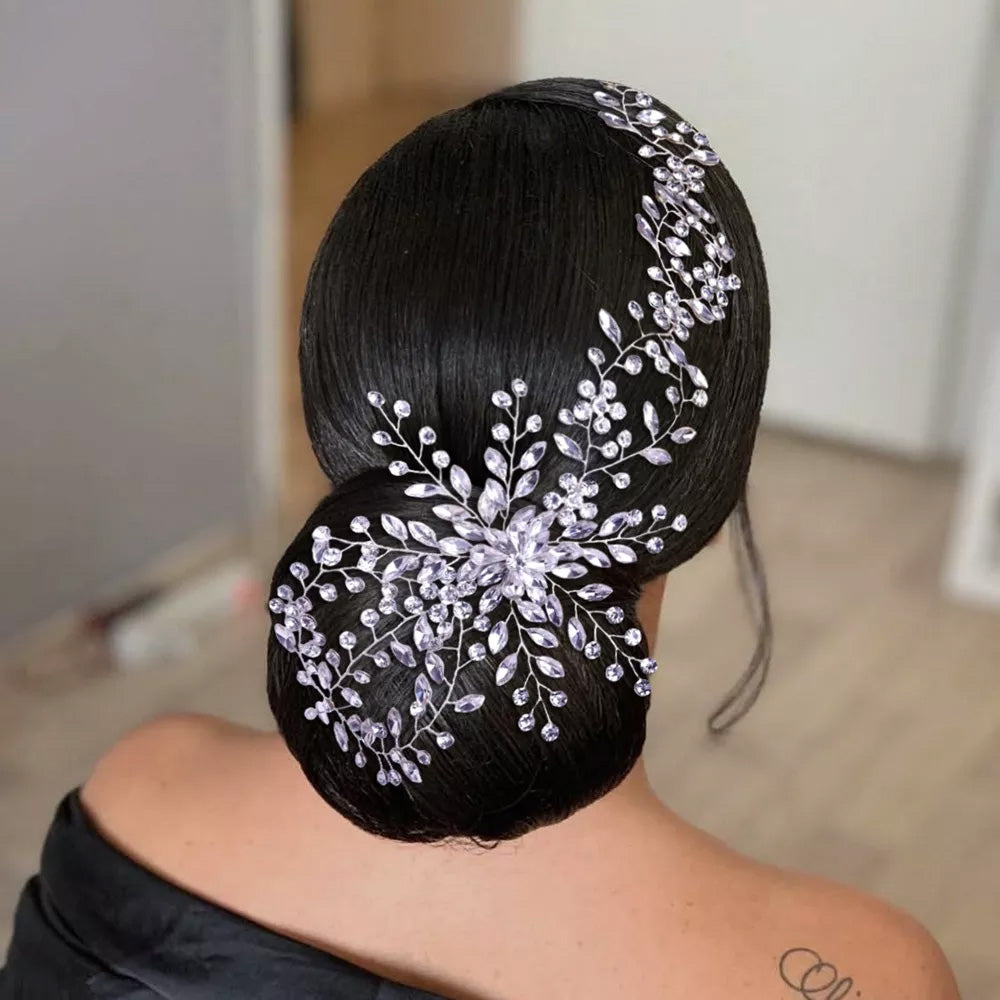 Alternate rear view of a brunette model with a sleek low bun showcasing the intricate weaving and delicate starburst crystal setting of a silver bridal hair vine clip.