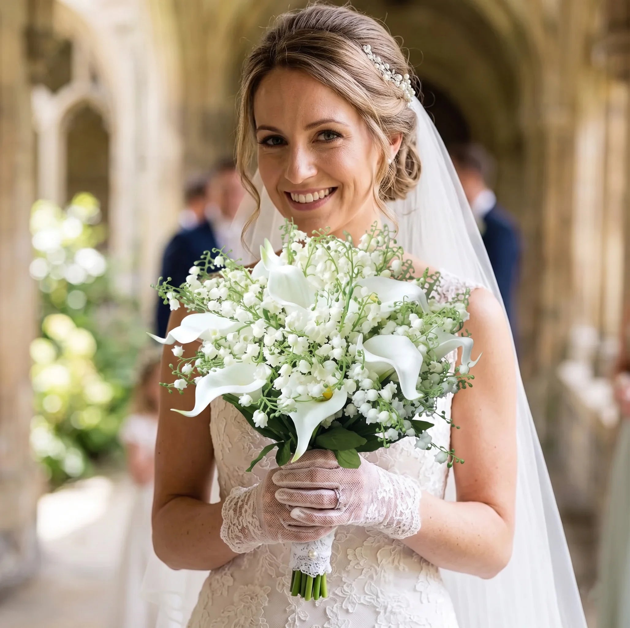 A bride holding a handmade artificial wedding bouquet featuring white calla lilies and lily of the valley.