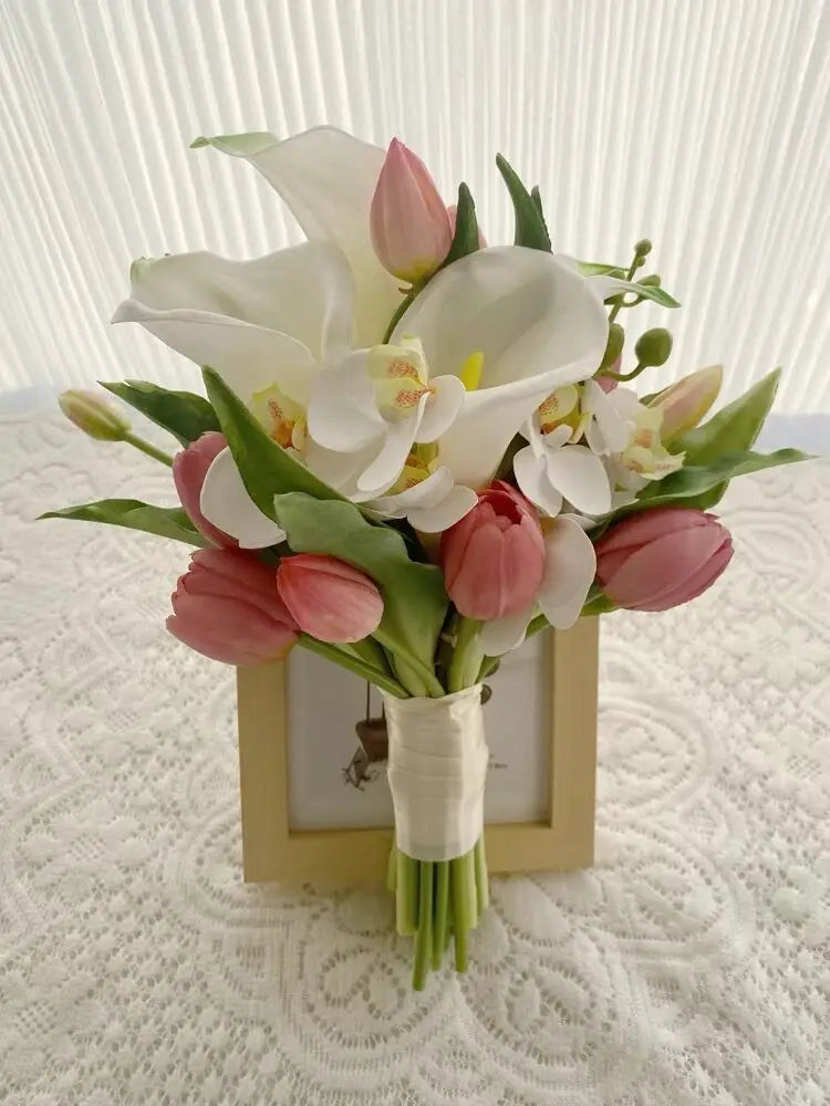 Handmade artificial bridal bouquet featuring white calla lilies, pink tulips, and white orchids with a simple handle wrap.