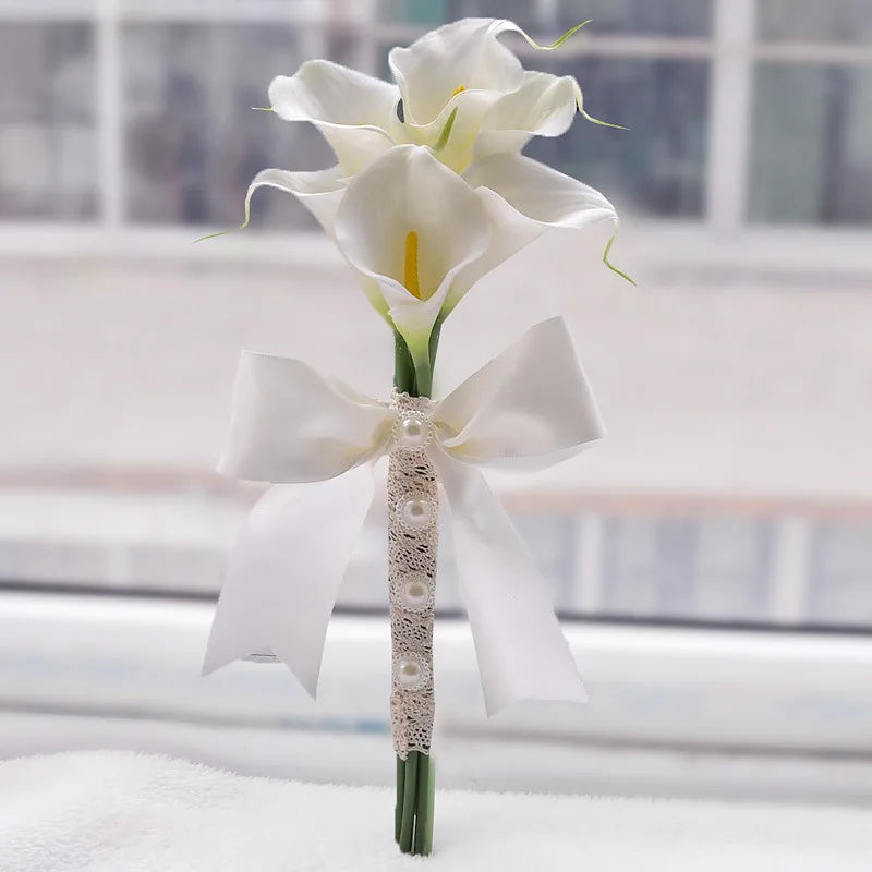Single handmade artificial calla lily boutonniere for weddings, featuring a white ribbon and lace detail.