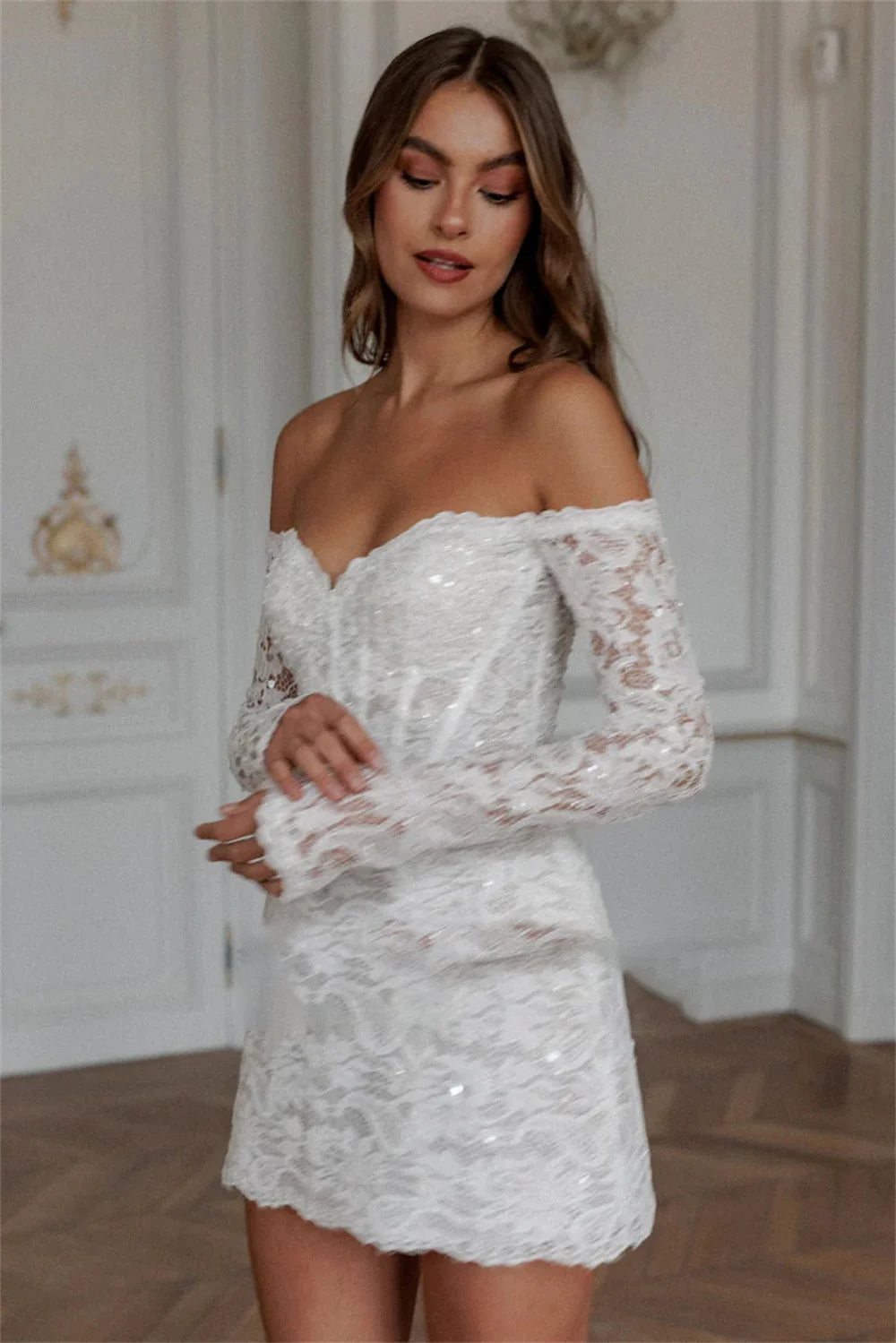Beautiful long-sleeve short lace wedding dress, emphasizing the delicate off-shoulder neckline and tailored A-line silhouette.