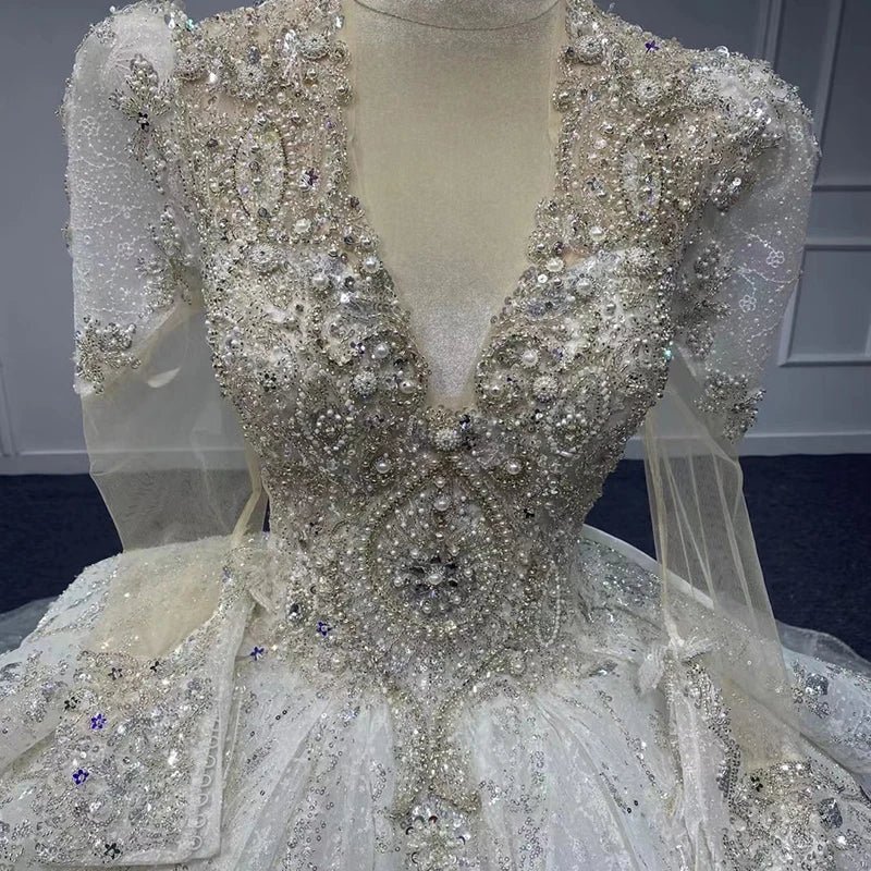 Full back view of a magnificent sparkling organza ball gown showing the massive volume of the skirt and the detailed patterns on the train.