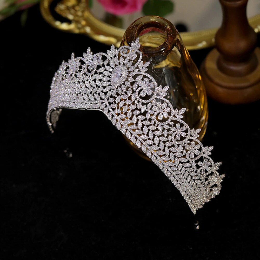 High-clarity cubic zirconia wedding crown tiara beautifully draped over a luxury amber glass display stand.