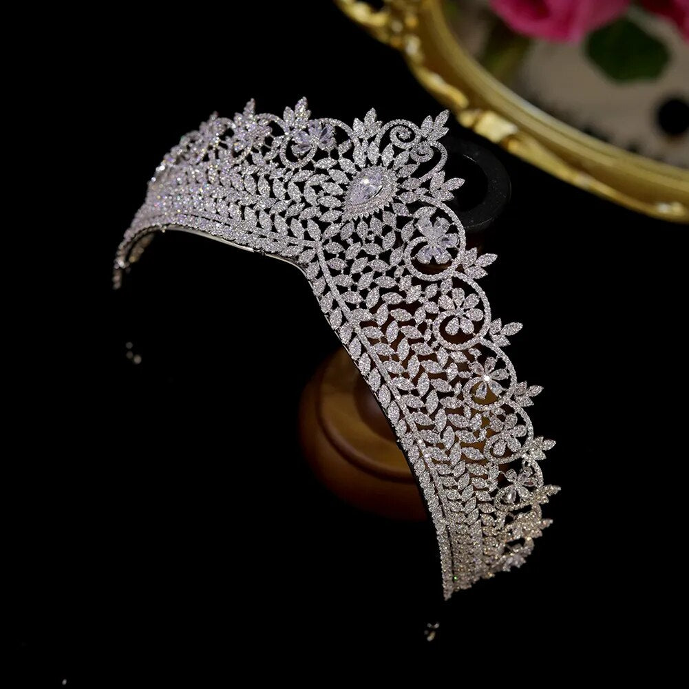 Top-down view of a luxury wedding bridal tiara handcrafted with brilliant cut zirconia stones resting on a dark velvet surface.