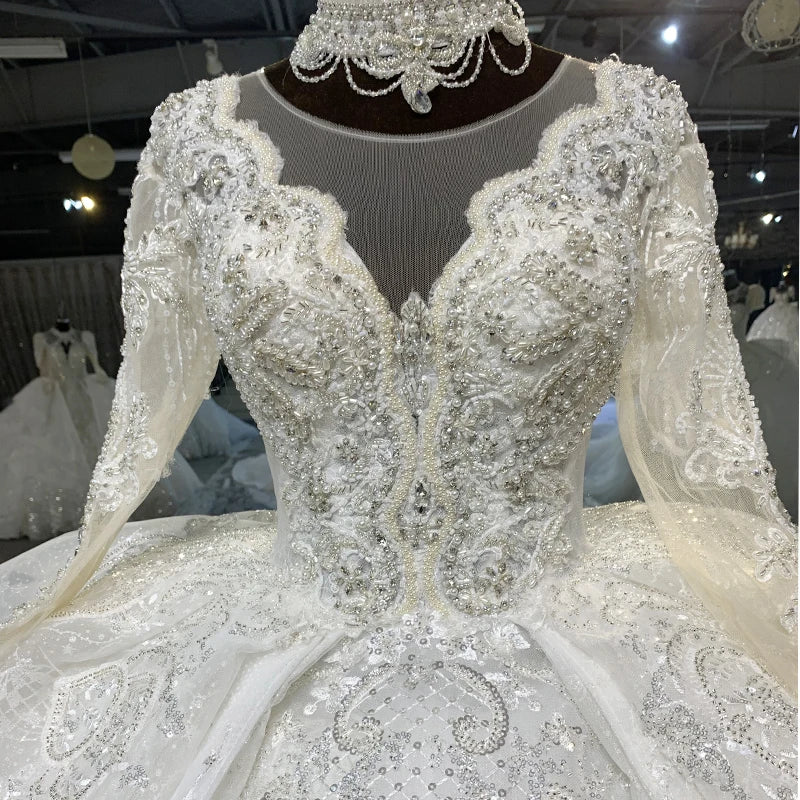 Detailed close-up of a bridal gown back, focusing on the classic white ribbon lace-up corset closure framed by delicate embroidered lace trims.