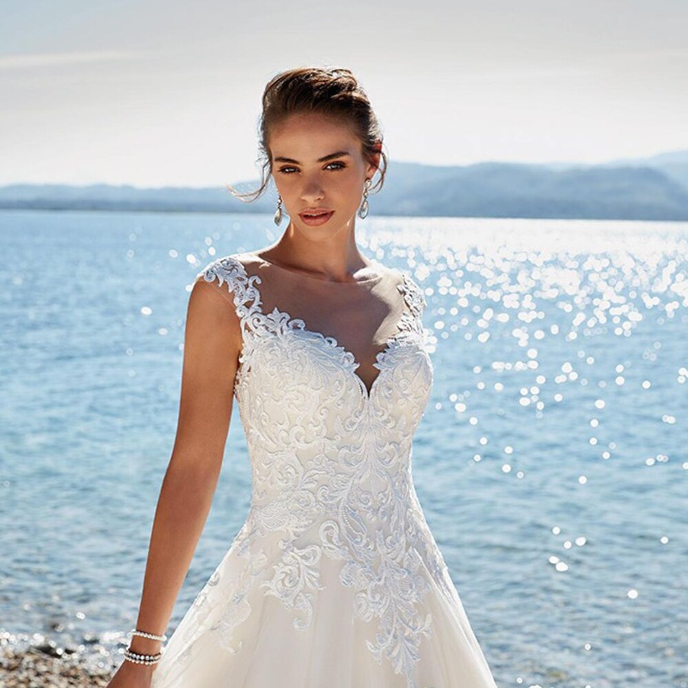 Close-up portrait of a bride wearing a sleeveless A-line wedding dress, highlighting the detailed lace embroidery on the bodice.