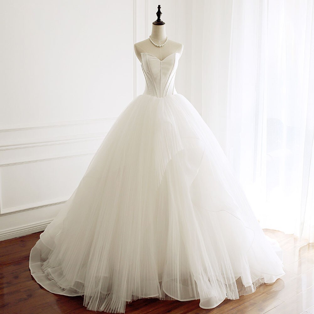 Mannequin showcasing the front profile of a strapless A-line wedding dress with structured corset bodice.