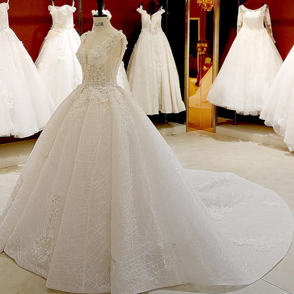 A princess-style wedding dress displayed in a showroom, featuring a V-neck and elaborate floral lace embroidery.