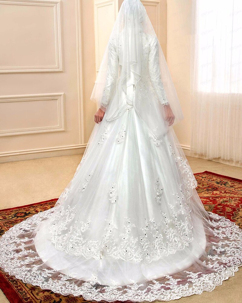 Back view of a beaded A-line Muslim bridal gown featuring a long, ornate lace train and traditional veil.