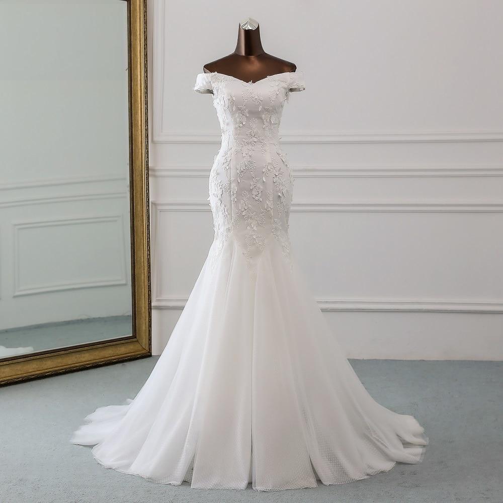 A stunning floor-length mermaid wedding dress with a sleek, sleeveless design, perfect for a modern bridal look.