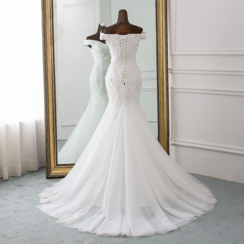 Graceful back view of an off-shoulder mermaid wedding gown featuring an elegant lace-up corset back.