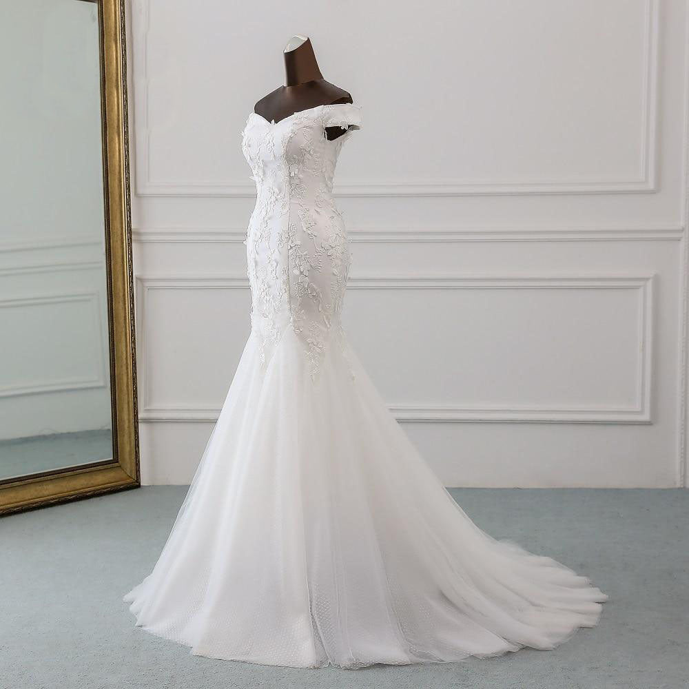 Detailed side view of a sleeveless off-shoulder bridal gown, highlighting the form-fitting bodice and flowing skirt.