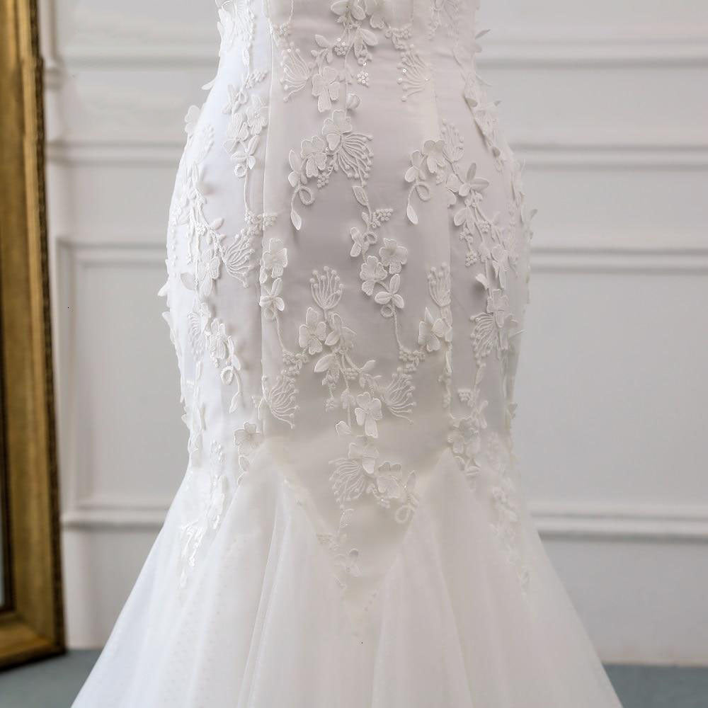 Close-up view of the exquisite lace detailing and floral appliques on the bodice of the mermaid wedding dress.