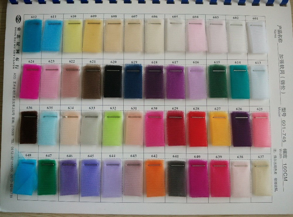 A comprehensive color swatch chart featuring numerous tulle fabric samples in a wide range of shades for custom bridal gown selection.