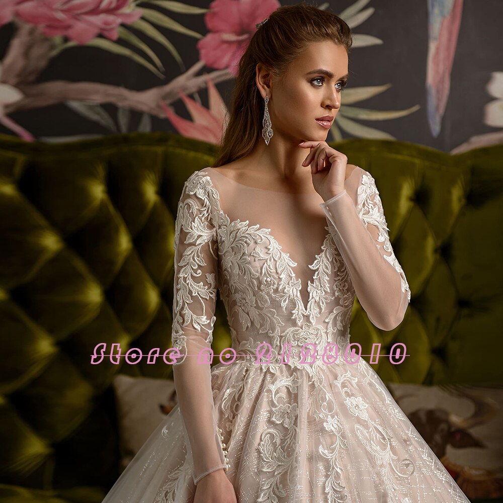 Close-up portrait of the bride looking away, wearing a shiny long-sleeve ball gown with intricate lace appliques on the bodice.