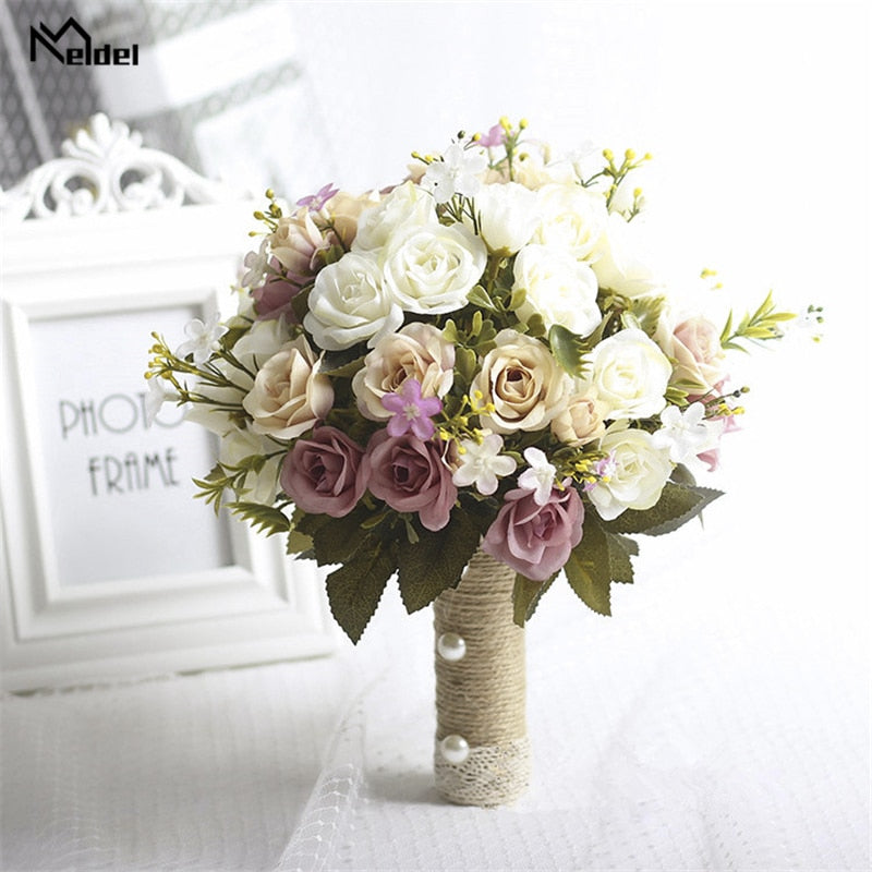Front perspective of a rustic-style artificial flower bridal bouquet containing dusty purple, cream, and champagne silk roses, featuring a twine-wrapped handle decorated with white pearls.