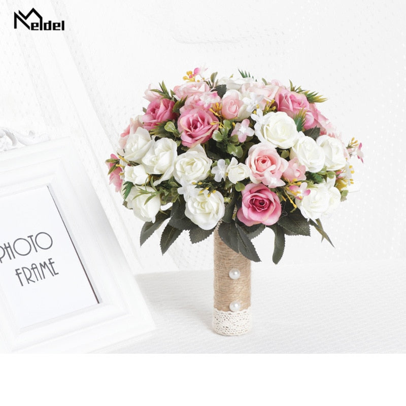Front view of a romantic silk wedding flower bouquet showcasing a vibrant mix of white, blush pink, and medium pink roses arranged with a twine handle and pearl details.