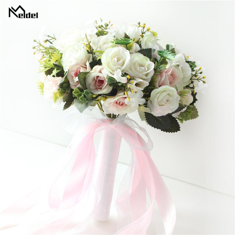Front view of a round artificial bridal bouquet displaying mixed white and blush pink silk roses, built with a white satin stem handle and matching sheer pink bow.
