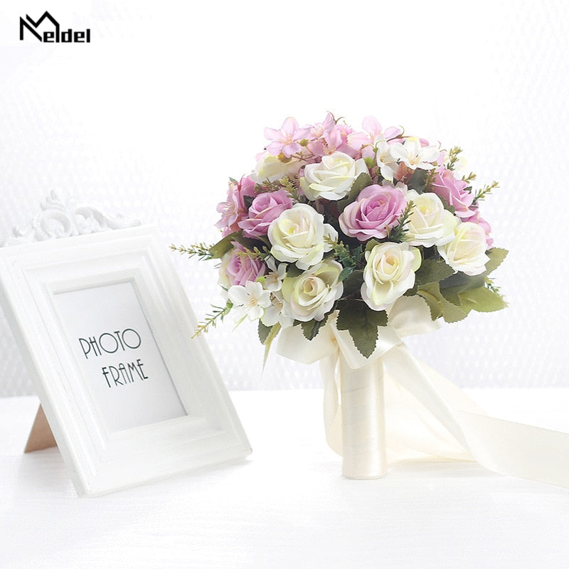 Symmetrical front perspective of a romantic artificial wedding flower arrangement composed of pastel purple and soft cream silk roses mixed with greenery.