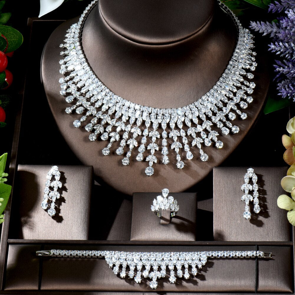 Direct studio view of the 4-piece crystal bridal wedding jewelry set neatly organized on a padded dark brown presentation display, capturing the intricate leaf and teardrop diamond-cut patterns.