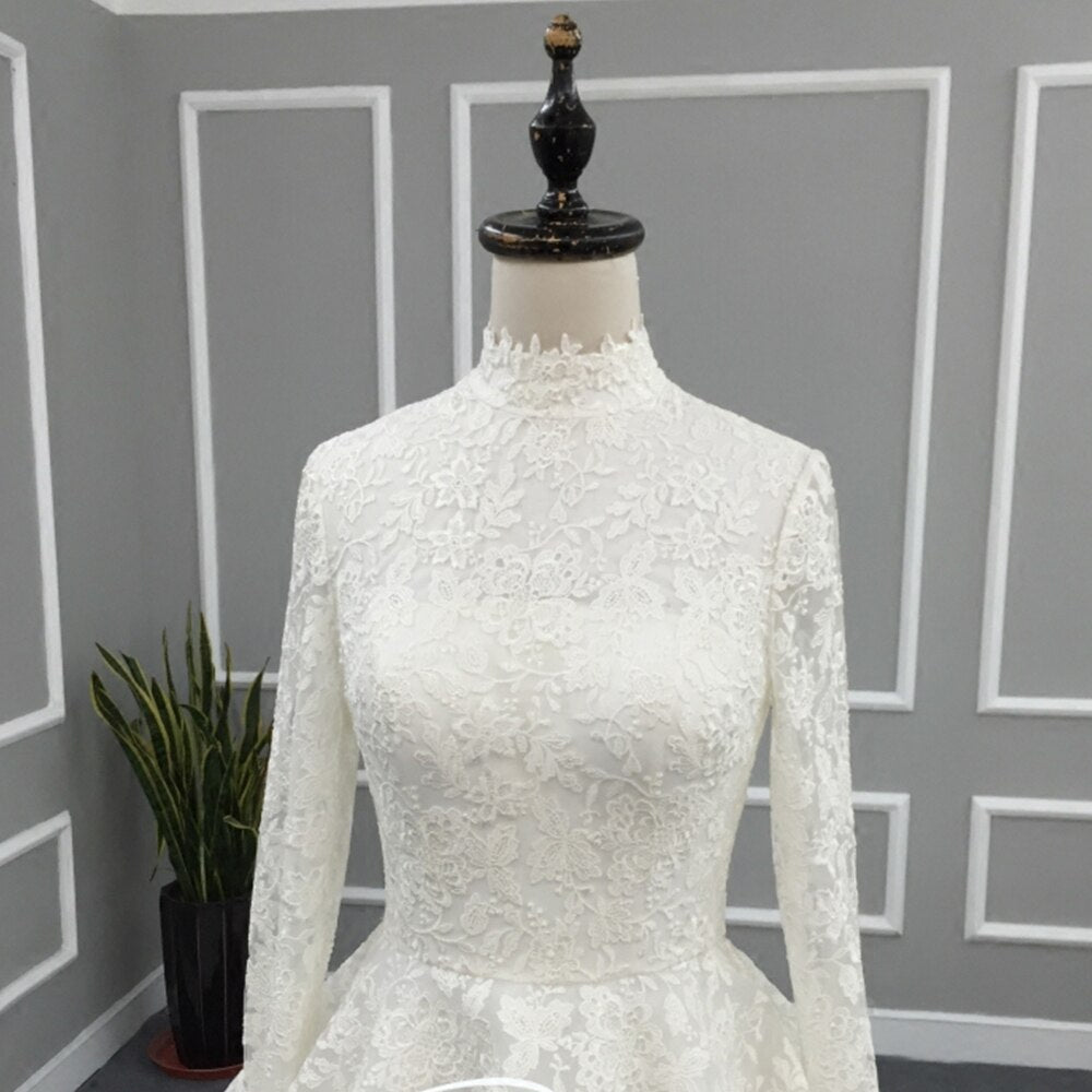 Close-up of the elegant high neck lace bodice detail on a long sleeve modest Muslim wedding dress.