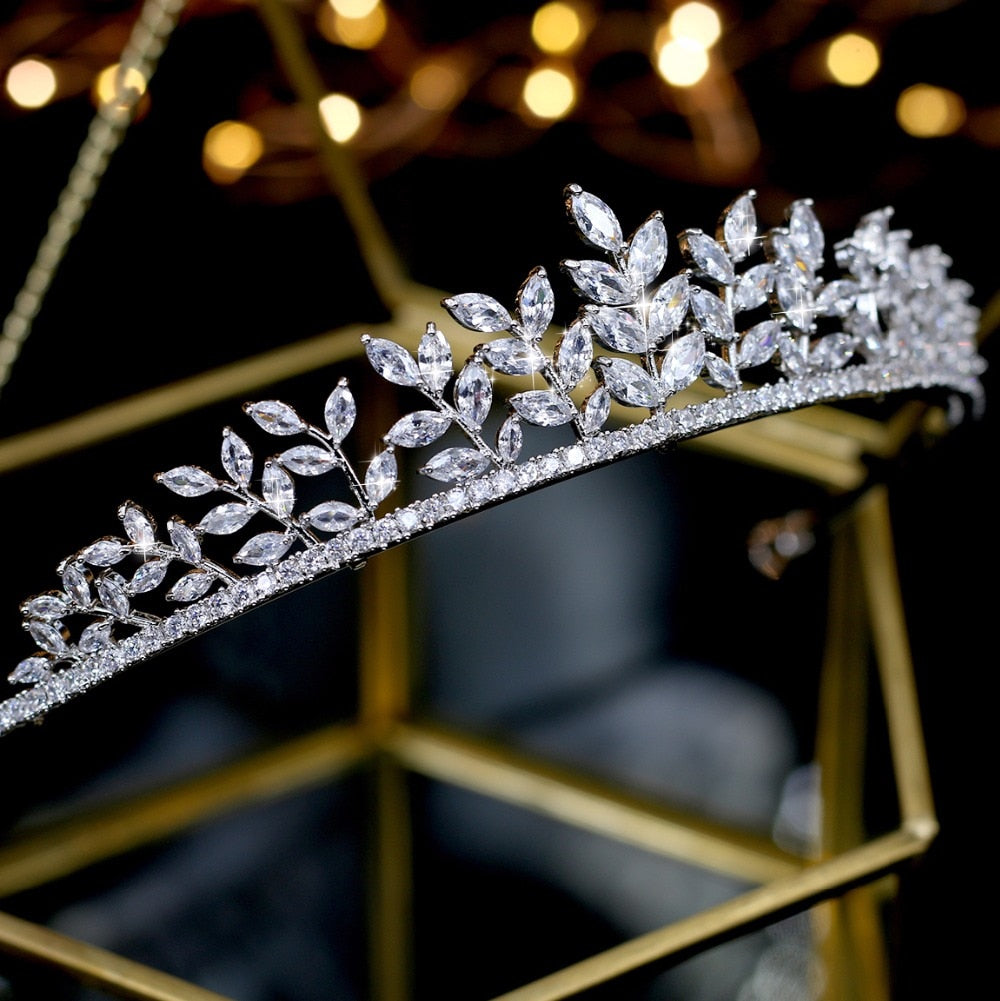 High-angle side view of the silver leaf rhinestone bridal crown headpiece, emphasizing the curved shape and the gradient height of the faceted marquise-cut crystal sprigs.