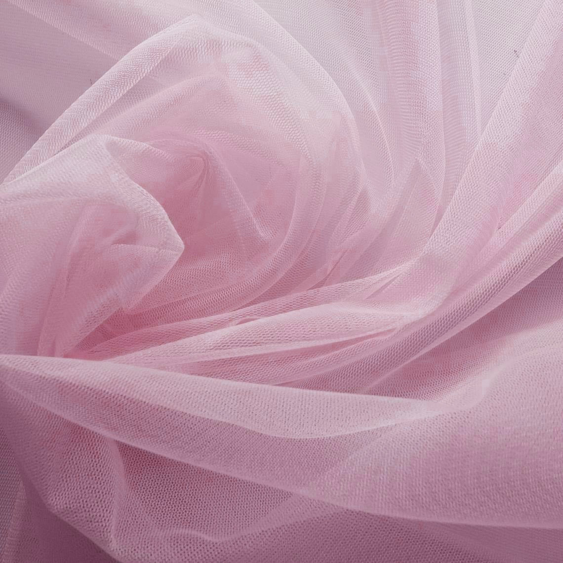 A close-up photograph showcasing the fine, elegant texture of sheer light pink tulle fabric for wedding dress layers.