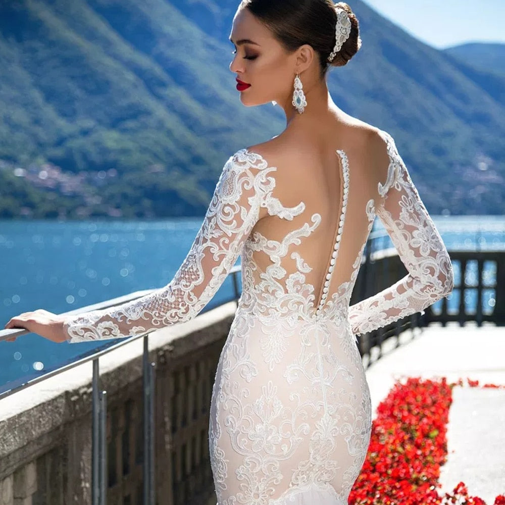 Detailed close-up of the back of a luxury long-sleeve mermaid wedding dress, emphasizing the intricate lace patterns and the refined row of delicate buttons along the illusion back.