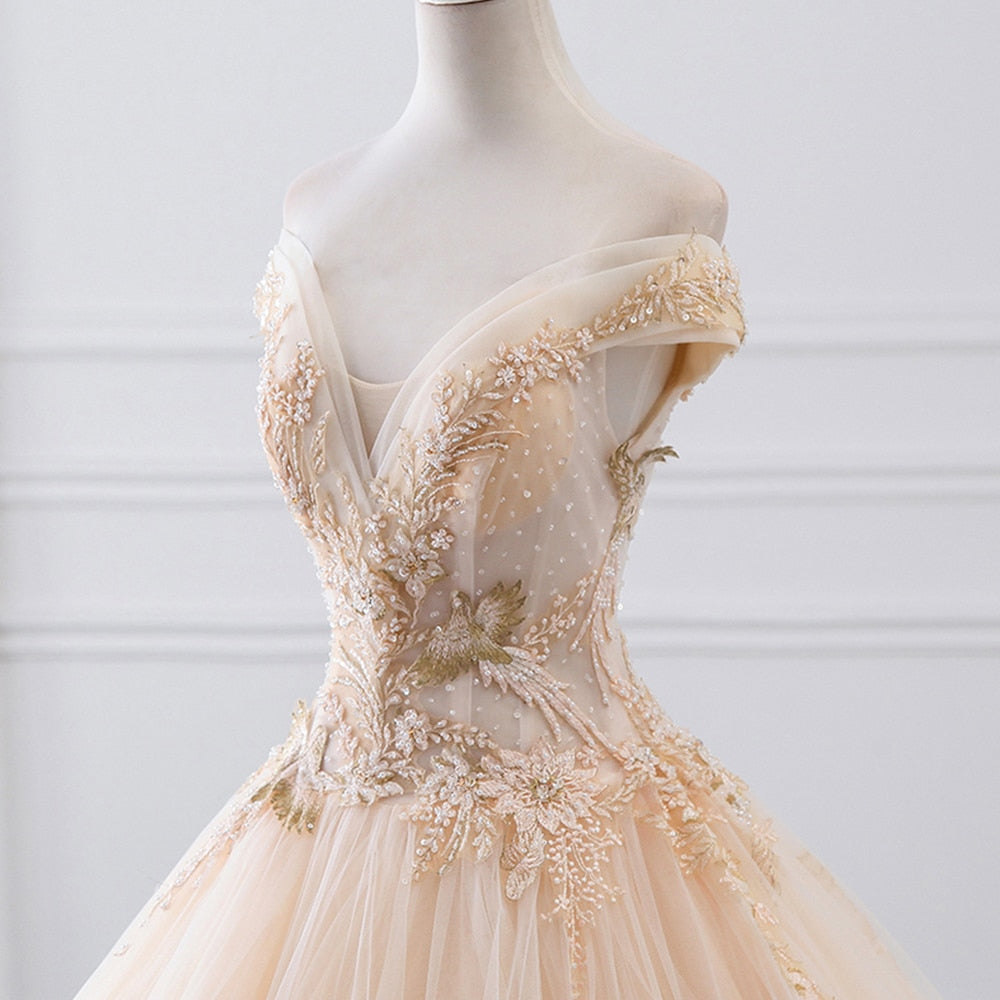 Close-up detail of the bodice on a luxury wedding dress, highlighting the exquisite craftsmanship of the sparkly beading, pearls, and gold-toned embroidery.