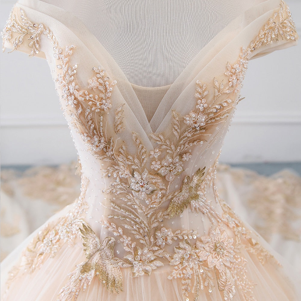 Detailed shot of the intricate floral-inspired sparkly beading and pearl decorations on the chest of a luxury wedding gown.