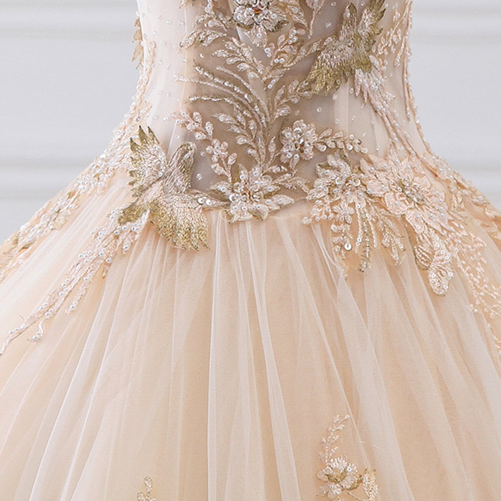 Full back view of a luxury ball gown wedding dress with a dramatic train, intricate pearl detailing, and a classic lace-up back.