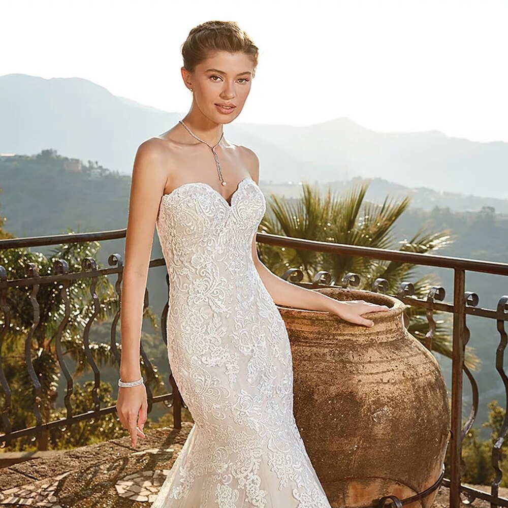 Close-up of a bride wearing a lace mermaid bridal gown with a sweetheart neckline and a delicate necklace.